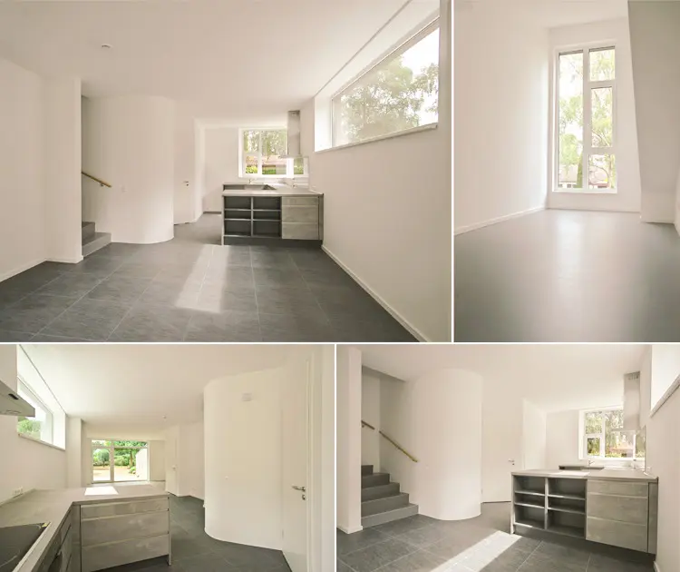 Hochwertige Fotografie einer leerstehenden, modernen Wohnung für Maklerexposés: Vier präzise komponierte Perspektiven zeigen die klare, helle Raumgestaltung mit organisch geschwungenen Wänden und großen Fenstern, die natürliches Licht einfluten lassen. Der dunkle Bodenbelag schafft einen eleganten Kontrast zu den weißen Wänden. Die funktionale Küche mit grauer Arbeitsplatte und Stauraum sowie die geschwungene Treppe unterstreichen die moderne Architektur. Die Bildkomposition betont die Raumwirkung, die hochwertige Verarbeitung und das Potenzial für individuelle Gestaltung – ideal für anspruchsvolle Immobilienpräsentationen.
